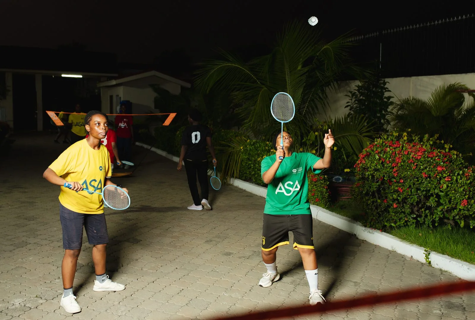 Two ASA students playing doubles badminton on campus