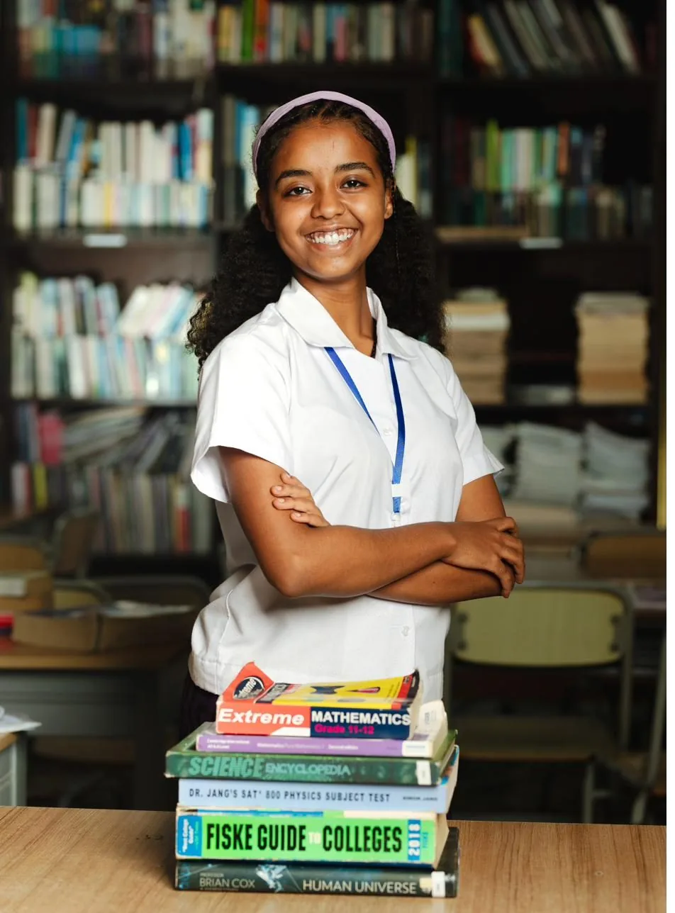 An ASA student in the academy library, holding study materials